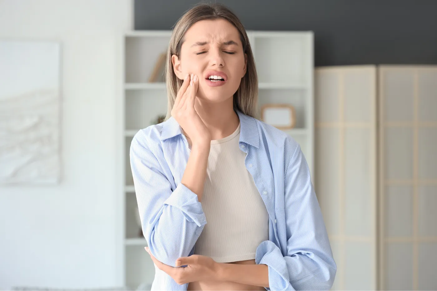 Person holding their jaw with a dental emergency
